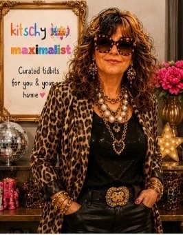 Stacie in a leopard jacket beside the Kitschy Maximalist sign and a disco ball